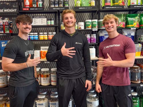 3 men posing in front of a wall of supplements at 5 star pocatello